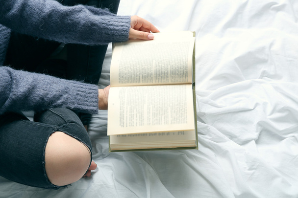 Woman in black jeans reading book - Фото, изображение