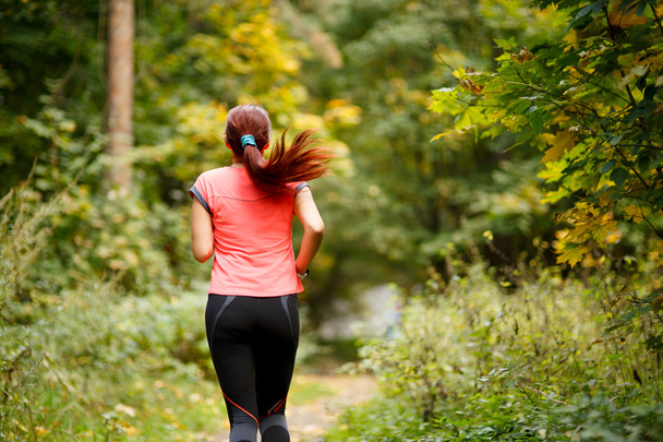 sporty  woman running in forest - Photo, Image