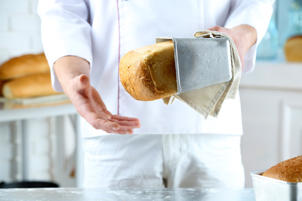 Пекарь проверяет свежеиспеченный хлеб
 - Фото, изображение