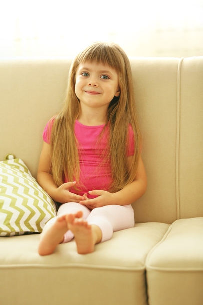 Beautiful little girl sitting on sofa - Foto, Imagem
