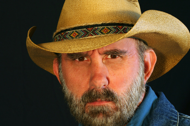 A Cowboy Squints Against a Black Background - Photo, Image