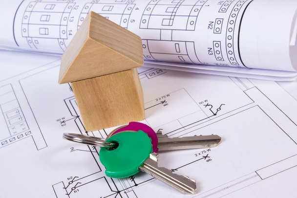 Дом из деревянных блоков, рулоны бревен и ключи от дома по строительному чертежу
 - Фото, изображение