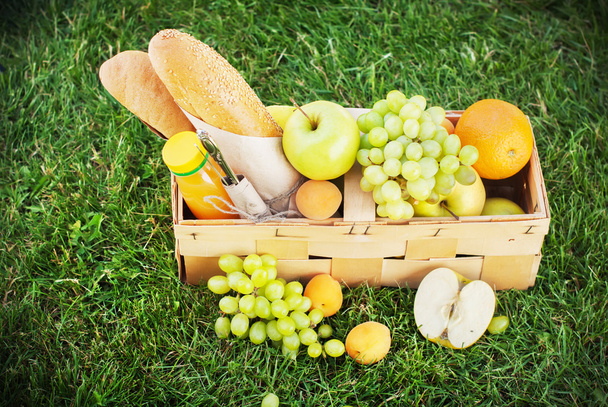 Fresh Summer Food in Picnic Basket on Green Grass - Photo, Image