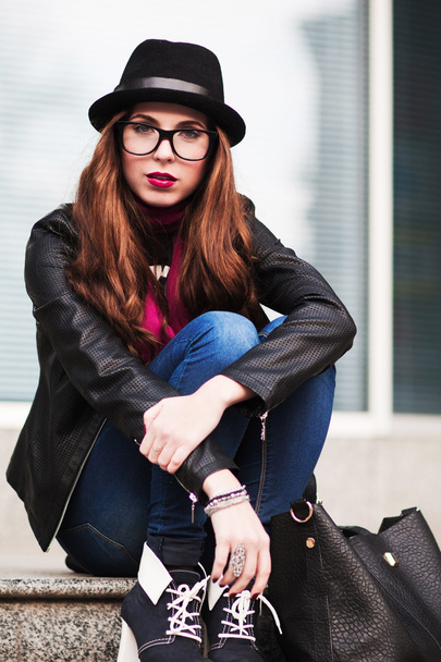 the stylish city girl in sunglasses  sits on steps - Fotoğraf, Görsel