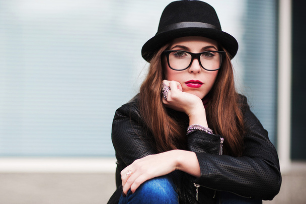 the stylish sad city girl in sunglasses leans a cheek on a hand - Фото, изображение