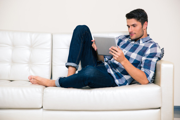 Man using tablet computer on the sofa - Photo, Image