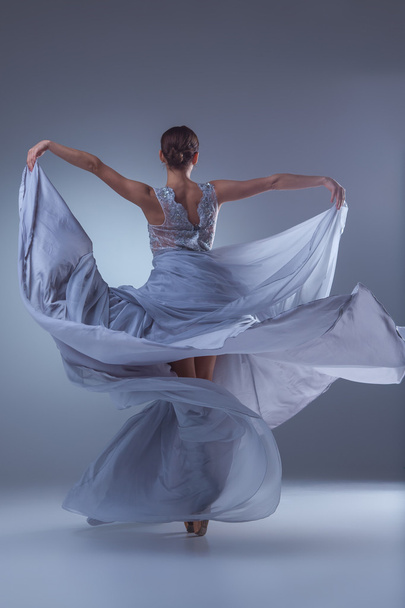 青いドレスで踊る美しいバレリーナ - 写真・画像