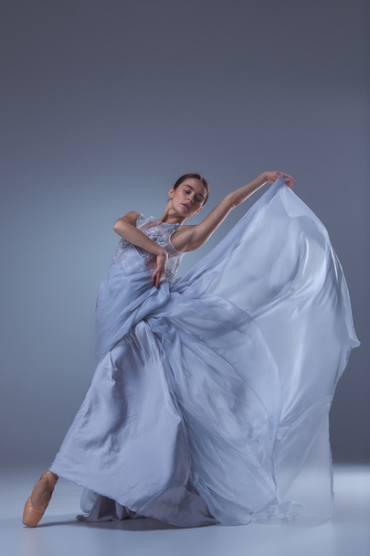The beautiful ballerina dancing in blue long dress - Фото, зображення