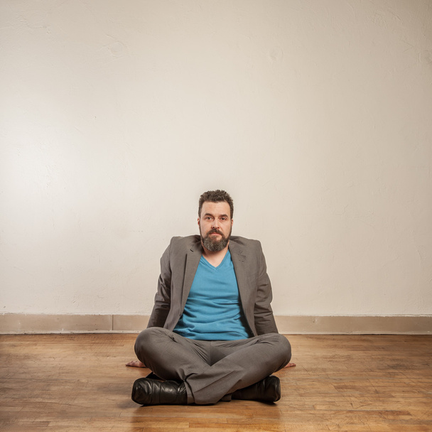Business man with beard, sitting on wooden floor - Φωτογραφία, εικόνα