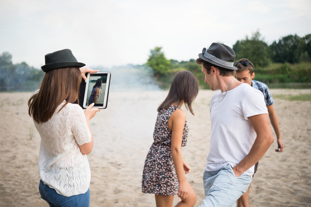 Adultos jóvenes tomando fotos y selfies en Sandy Beach
 - Foto, Imagen