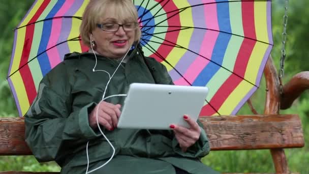 Žena s deštníkem komunikuje prostřednictvím počítače tablet Pc - Záběry, video