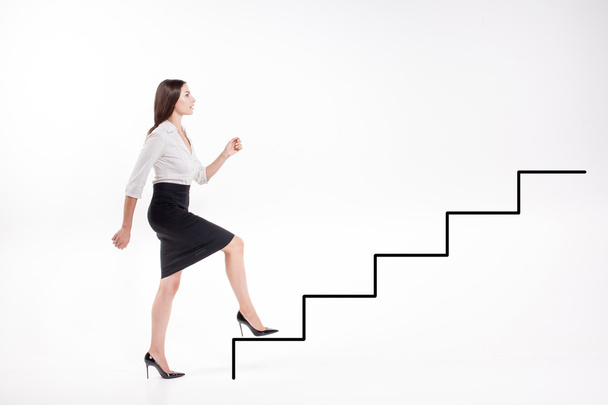 Young businesswoman walking up on stairs - Photo, Image