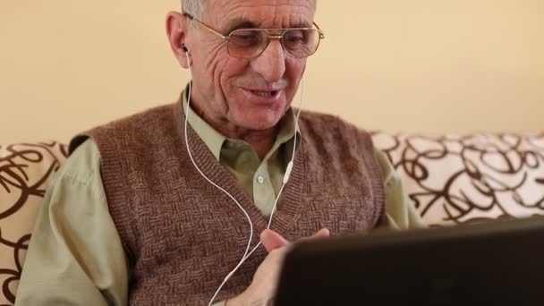Ανώτερος άνθρωπος επικοινωνεί μέσω φορητού υπολογιστή - Πλάνα, βίντεο