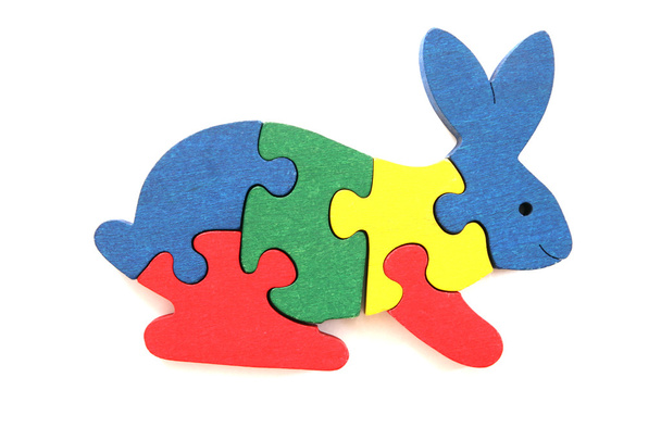Puzzle in legno colorato a forma di coniglio su sfondo bianco
 - Foto, immagini