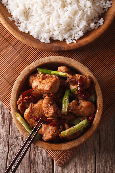 Kurczaka Kung pao w misce z bliska i ryż. pionowe widok z góry - Zdjęcie, obraz
