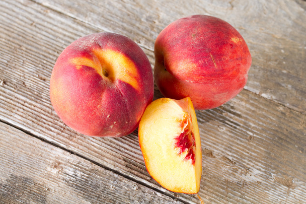 Ripe whole and sliced peaches - Foto, afbeelding