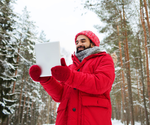 happy man with tablet pc in winter forest - Fotoğraf, Görsel