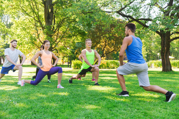 group of friends or sportsmen exercising outdoors - Fotoğraf, Görsel
