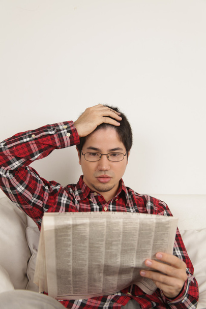 Hombre leyendo el periódico y preocupado por las noticias
 - Foto, imagen