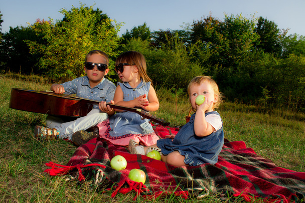 春の公園で、屋外の緑の芝生の上に横たわる幸せな子供たちのグループ - 写真・画像