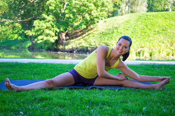 feliz joven mujer haciendo estiramientos ejercicios en el Parque - Foto, Imagen