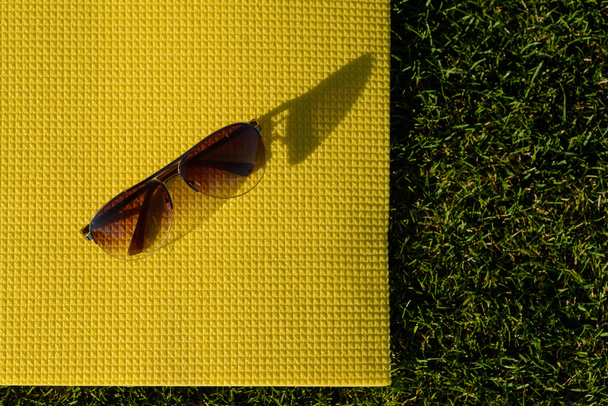 Sunglasses lying on a yoga mat - 写真・画像