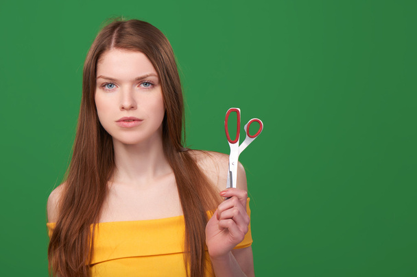 Calm redhead woman holding scissors - Valokuva, kuva