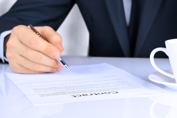 Close-up van zakenman hand te drukken een stempel op het document in het kantoor - Foto, afbeelding