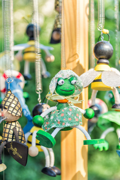 Miniatyyri puinen sammakko lelu roikkuu
 - Valokuva, kuva
