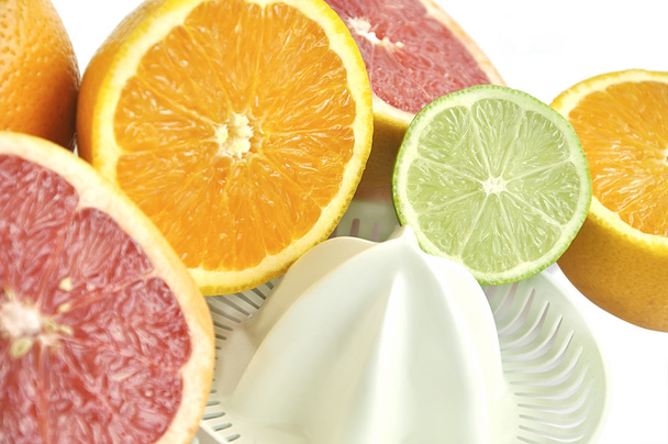Juicer met segmenten van grapefruit, oranje en lime. - Foto, afbeelding