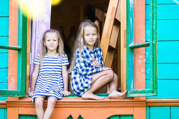 Adorables petites filles dans la fenêtre de la maison rurale en plein air
 - Photo, image