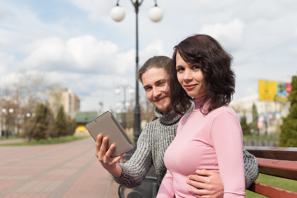 Les jeunes étudiants à la mode couple en ville en utilisant la tablette
 - Photo, image