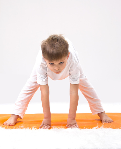 Baby yoga. The little boy does exercise. - Foto, imagen