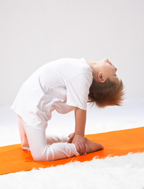 kinderen van yoga. de kleine jongen oefent. - Foto, afbeelding