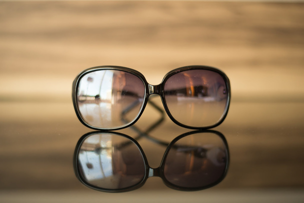 Sahilde tablo pozlama üzerinde güneş gözlüğü - Fotoğraf, Görsel