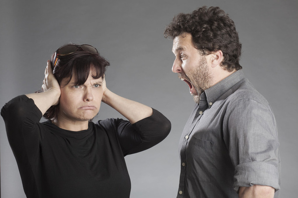 Mature couple quarreling man shouting woman covering ears - Fotografie, Obrázek