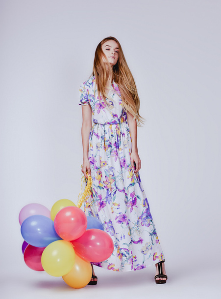 fashion studio photo of beautiful model woman with blond hair in dress holding colorful balloons - Foto, Imagem