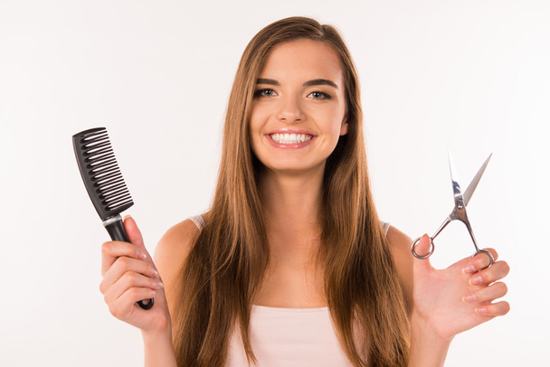 girl choosing between scissors and comb - Foto, Imagen