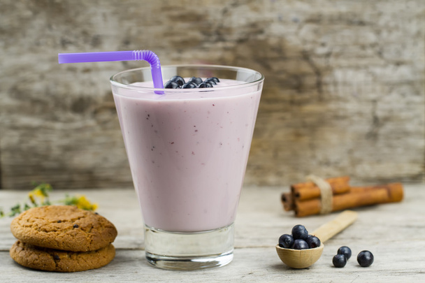 Blueberry smoothie with berries, cinnamon, oat cookies on wooden background. Healthy vegetarian food, diet. - Foto, imagen