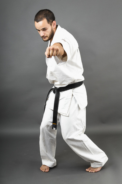Full length portrait of young man in white kimono and black belt - Foto, Bild