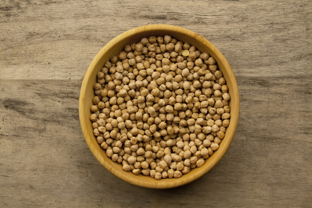 bunch of chickpeas in bowl on old wooden background. Indian cuisine - Photo, Image