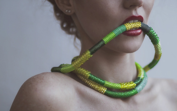 Portrait of a beautiful young woman with a necklace of beads in - Photo, Image