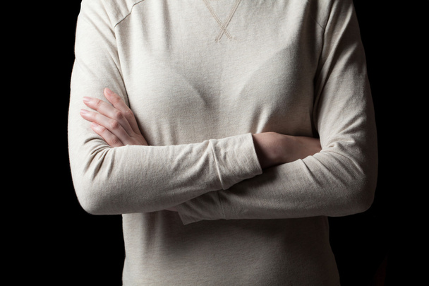Young woman standing with folded hands, isolated on black backgr - Photo, Image