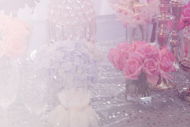 wijnglas, kandelaar, stelletje paars hortensia, roze roos een - Foto, afbeelding