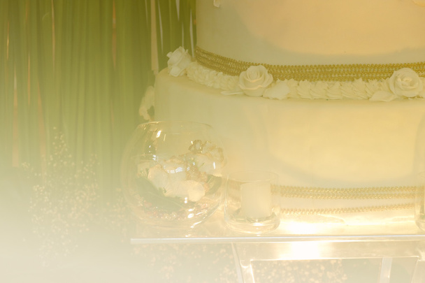 искусственное украшение цветов в стекло и белый свадебный торт остроумие
 - Фото, изображение