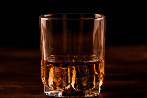 glass of whiskey with ice on a wooden table. Cognac, brandy. - Fotoğraf, Görsel