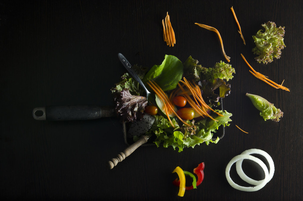 Vegetable salad preparation on black background - Photo, Image