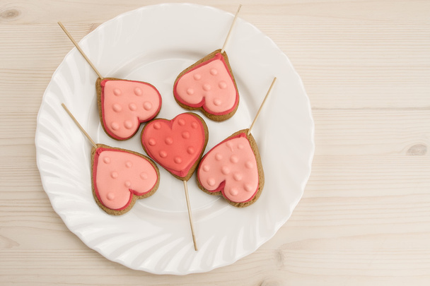 delicious fresh cookies on a white plate in the form of heart on a wooden background. - Фото, зображення