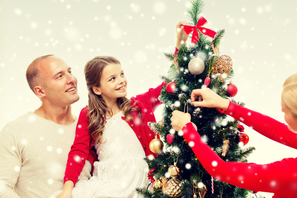 smiling family decorating christmas tree at home - Φωτογραφία, εικόνα