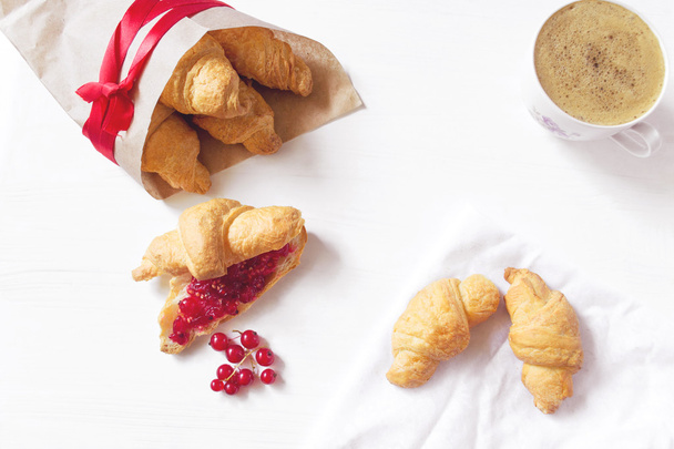 Croissantit punaherukan hillolla ja kahvilla
 - Valokuva, kuva